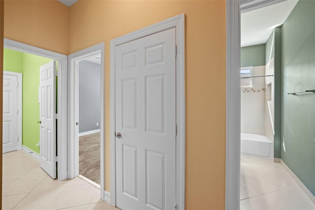 hall with baseboards and light tile patterned flooring