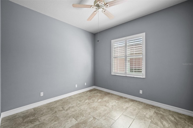 spare room featuring baseboards and ceiling fan