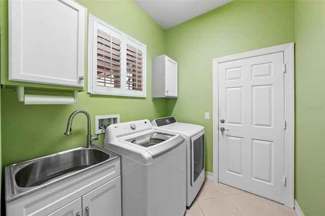 washroom featuring baseboards, light tile patterned flooring, cabinet space, a sink, and independent washer and dryer