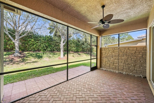 unfurnished sunroom featuring ceiling fan