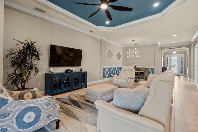 living room featuring visible vents, ornamental molding, ceiling fan with notable chandelier, arched walkways, and light tile patterned floors