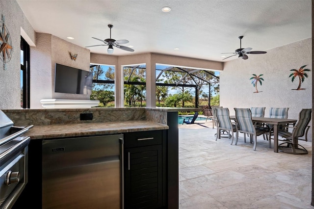 view of patio / terrace featuring glass enclosure, outdoor dining area, area for grilling, and ceiling fan