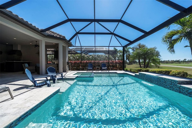 outdoor pool featuring ceiling fan, a jacuzzi, glass enclosure, and a patio