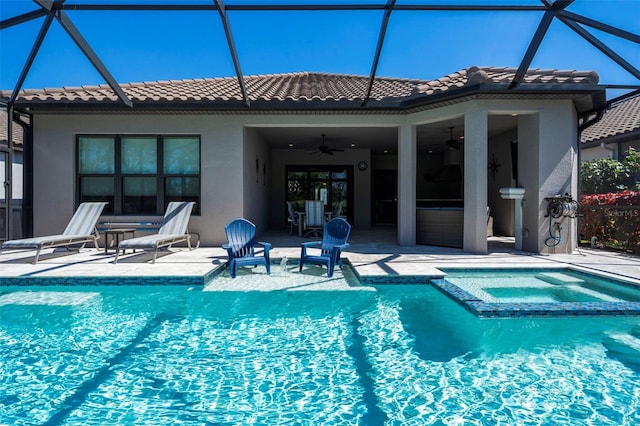 view of pool featuring a lanai, a pool with connected hot tub, ceiling fan, and a patio area