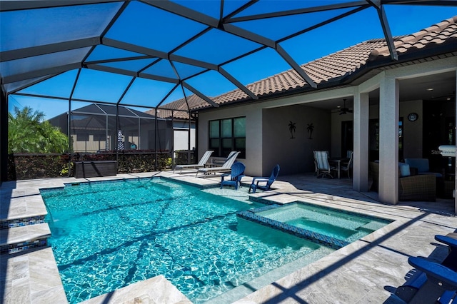 view of pool with a patio area, a lanai, a pool with connected hot tub, and a ceiling fan