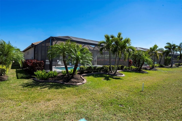 view of yard featuring glass enclosure and an outdoor pool