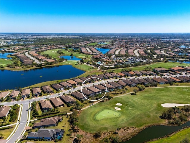 drone / aerial view featuring view of golf course, a residential view, and a water view