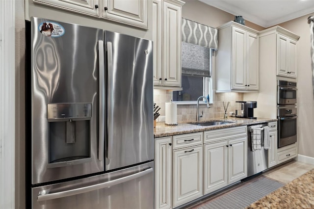 kitchen with a sink, tasteful backsplash, stainless steel appliances, crown molding, and light stone countertops