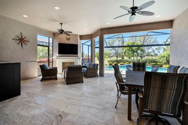 view of patio / terrace featuring an outdoor pool, glass enclosure, an outdoor hangout area, and a ceiling fan