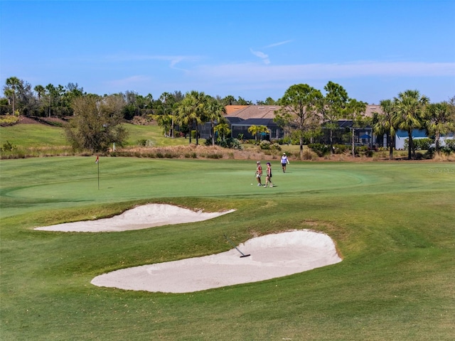 view of home's community featuring a yard and view of golf course