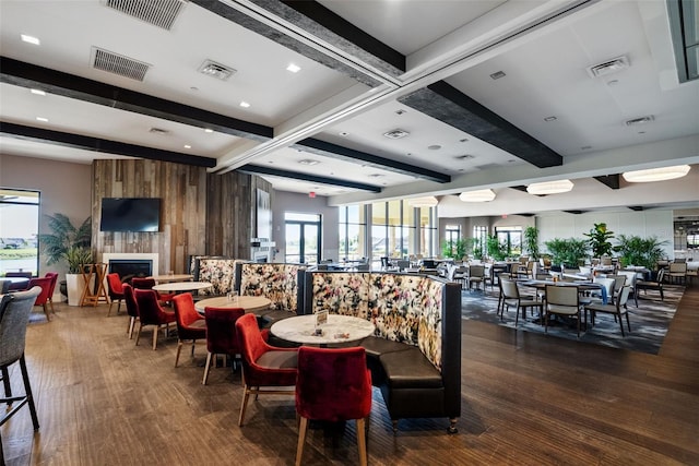 dining room with a fireplace, beamed ceiling, dark wood-style floors, and visible vents