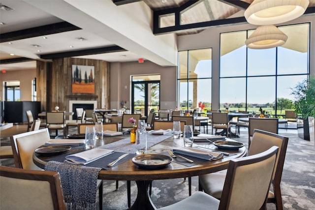 carpeted dining room with beam ceiling, a high ceiling, and visible vents