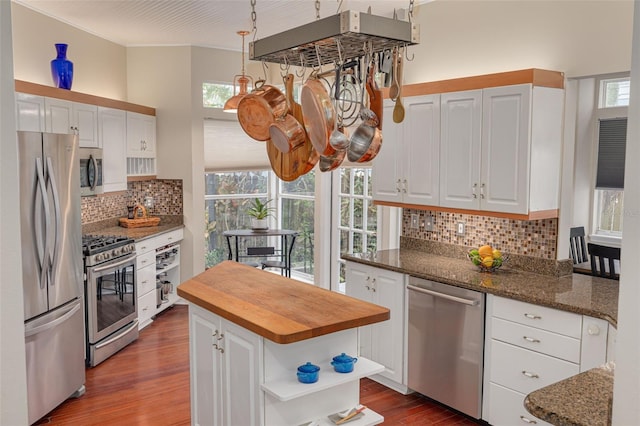 kitchen featuring stainless steel appliances, a kitchen island, white cabinets, wooden counters, and dark wood finished floors