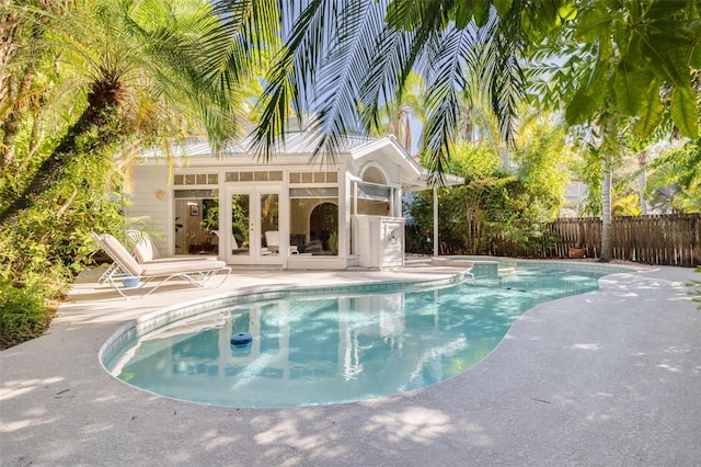 view of swimming pool featuring a fenced in pool, an outbuilding, a patio, an exterior structure, and fence