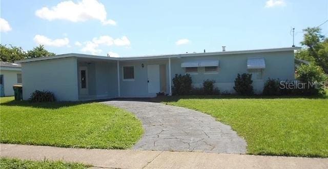 ranch-style home with a front lawn, aphalt driveway, a carport, and stucco siding