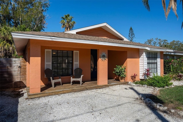 back of property featuring stucco siding and roof with shingles