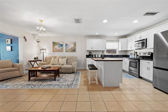 kitchen with dark countertops, visible vents, open floor plan, and stainless steel appliances