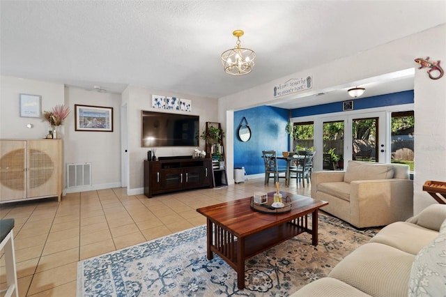 living room with tile patterned flooring, an inviting chandelier, baseboards, and visible vents