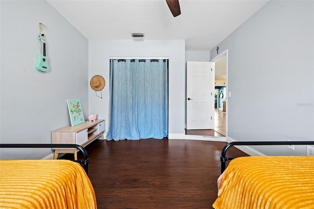 bedroom featuring visible vents, a ceiling fan, wood finished floors, a closet, and baseboards