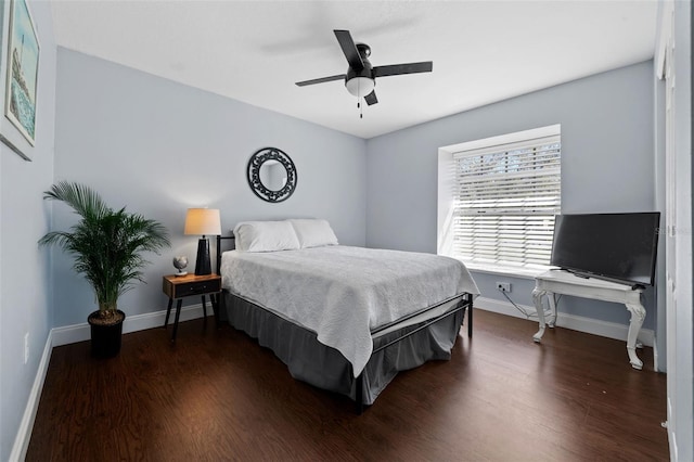 bedroom with baseboards, dark wood-type flooring, and a ceiling fan