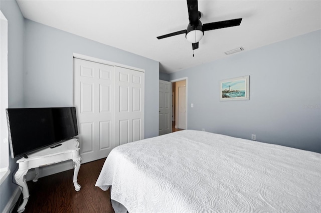 bedroom featuring dark wood-type flooring, visible vents, a closet, and ceiling fan