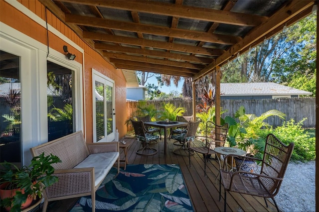 wooden terrace featuring outdoor dining space and a fenced backyard