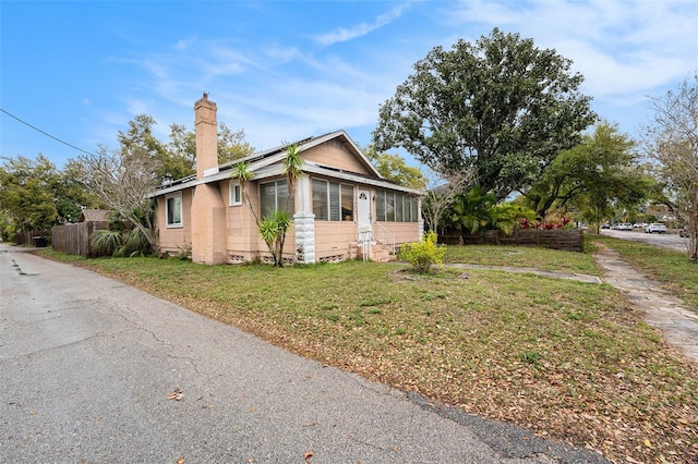 view of front facade featuring crawl space, a chimney, a front yard, and fence