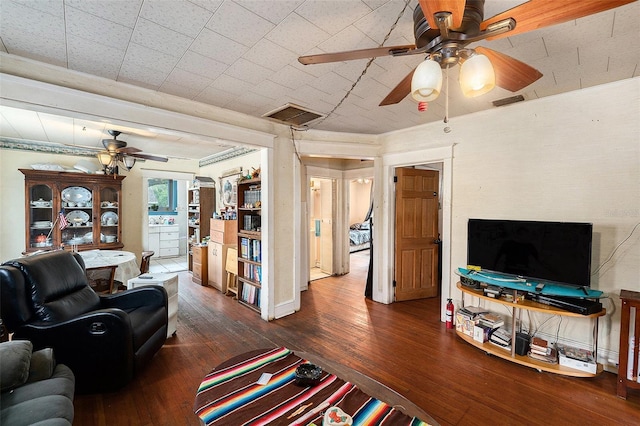 living area featuring wood-type flooring, visible vents, and a ceiling fan