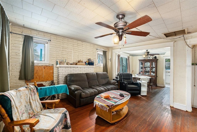 living room featuring a ceiling fan, wood-type flooring, visible vents, and baseboards