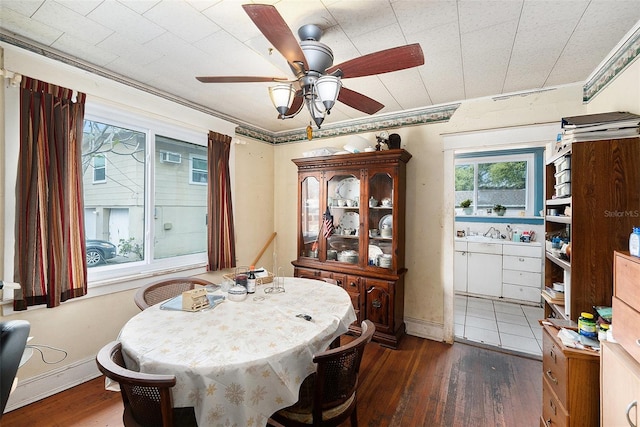 dining space with baseboards, dark wood finished floors, and a ceiling fan