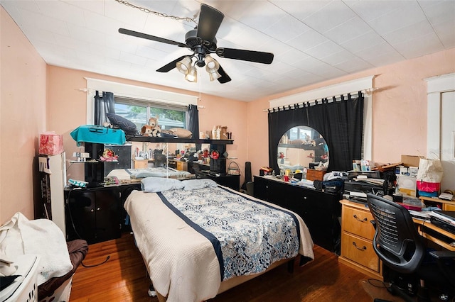 bedroom with ceiling fan and dark wood finished floors