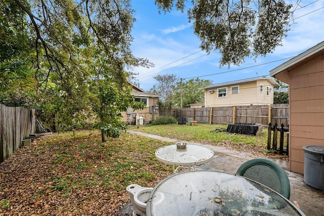 view of yard with a patio area, outdoor dining area, and a fenced backyard