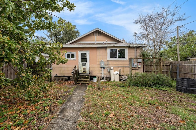 back of house featuring entry steps and fence