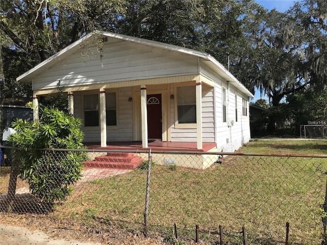 bungalow with a fenced front yard, a porch, and a front lawn