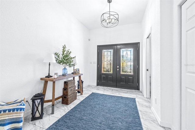 foyer featuring marble finish floor, baseboards, french doors, and an inviting chandelier