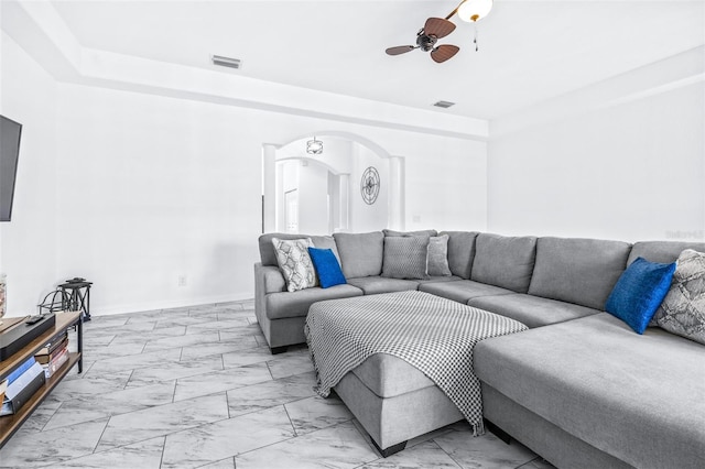 living area with visible vents, arched walkways, baseboards, ceiling fan, and marble finish floor