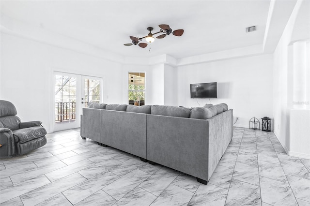 living area featuring marble finish floor, french doors, visible vents, and a ceiling fan