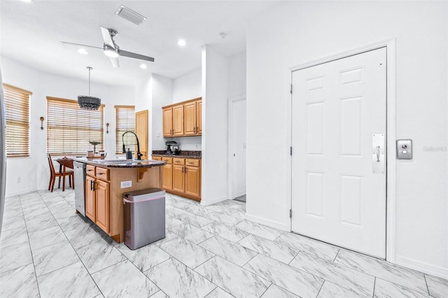 kitchen with ceiling fan, a kitchen island with sink, a sink, marble finish floor, and stainless steel dishwasher