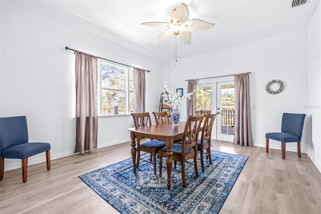 dining room with light wood finished floors, french doors, visible vents, and baseboards