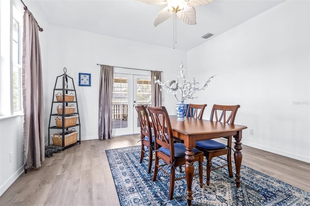 dining area featuring light wood finished floors, baseboards, visible vents, and ceiling fan