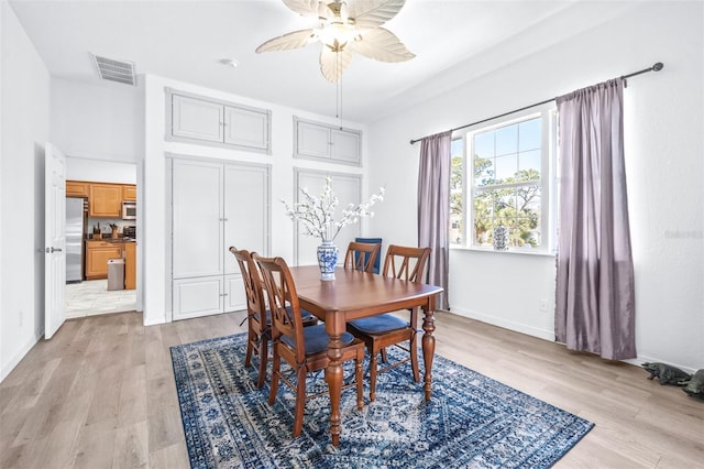 dining area featuring baseboards, visible vents, ceiling fan, and light wood finished floors