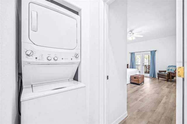 washroom featuring light wood-style floors, stacked washer / dryer, french doors, and a ceiling fan