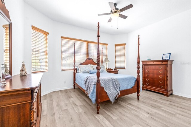 bedroom with ceiling fan, light wood-style flooring, and baseboards