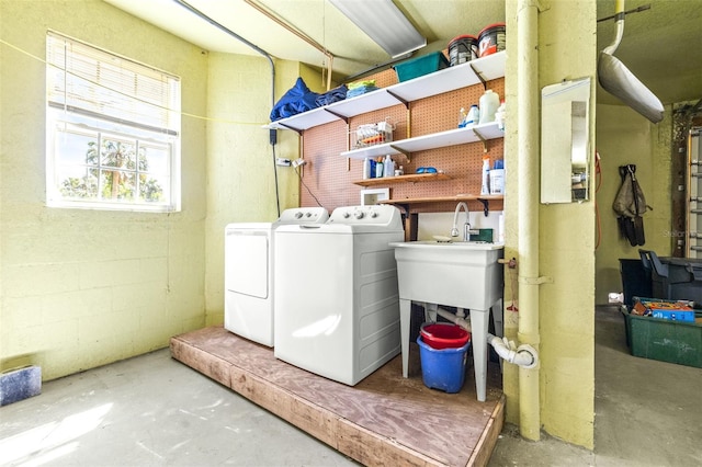 laundry area with concrete block wall, laundry area, and washer and clothes dryer