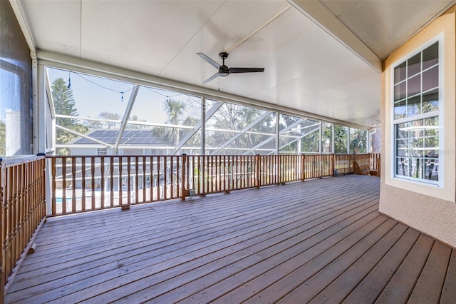 wooden deck with a lanai and a ceiling fan