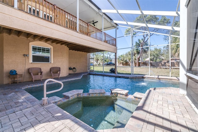 view of swimming pool featuring a pool with connected hot tub, a patio, and a lanai