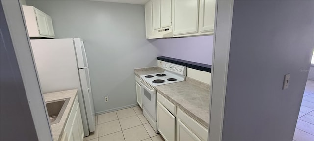 kitchen with light tile patterned floors, light countertops, white cabinetry, a sink, and white appliances