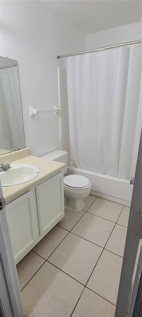 full bathroom featuring tile patterned flooring, vanity, toilet, and shower / bath combo with shower curtain