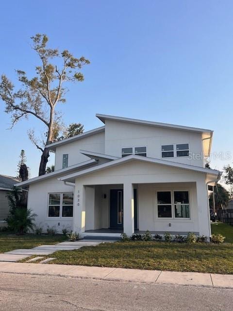 view of front of home with stucco siding and a front yard