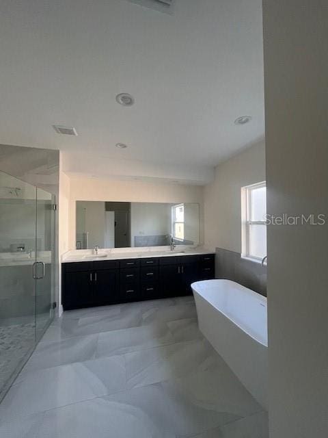 bathroom with double vanity, a stall shower, visible vents, a soaking tub, and a sink